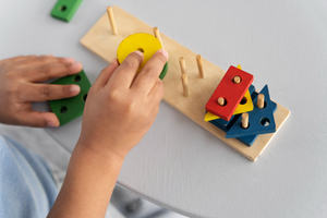Child developing problem-solving and fine motor skills with a wooden learning toy at Welmont Preschool in Jaipur