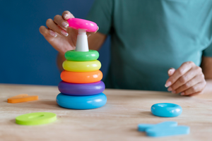 Child developing fine motor skills and hand-eye coordination with a stacking toy at Welmont Preschool in Jaipur